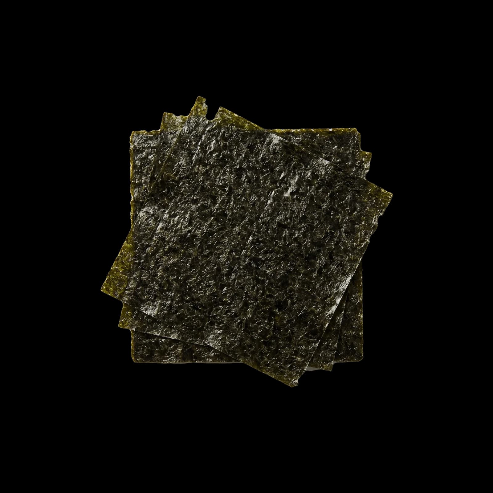 Stacked sheets of dried nori, showing the dark even surface and the edge of the stack.