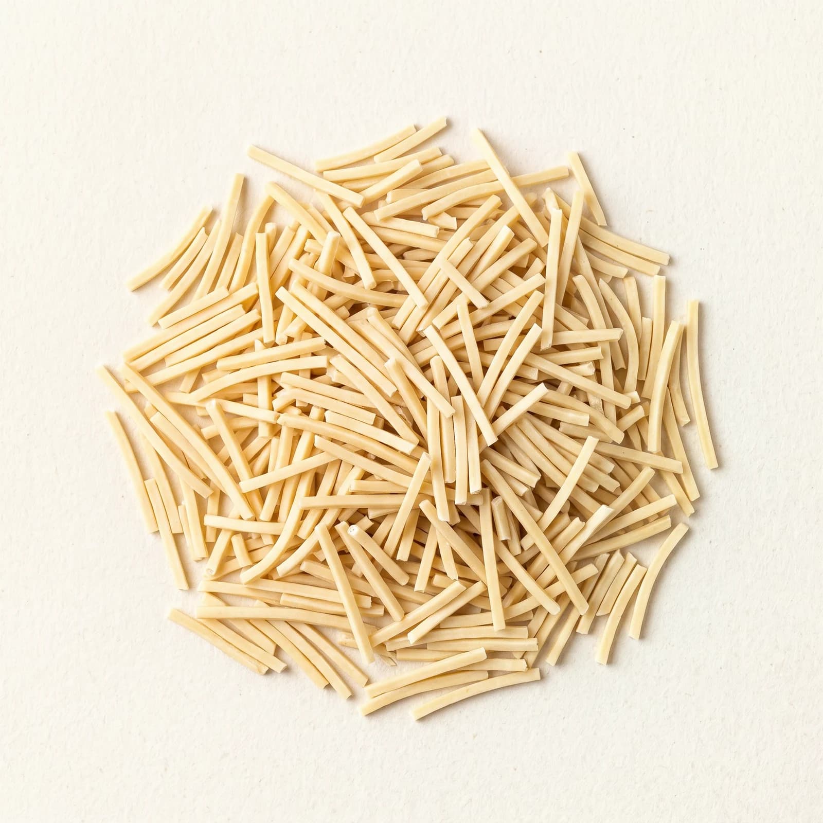 Close view of dry ramen strands, showing the cut width and the uniform surface of the noodle.