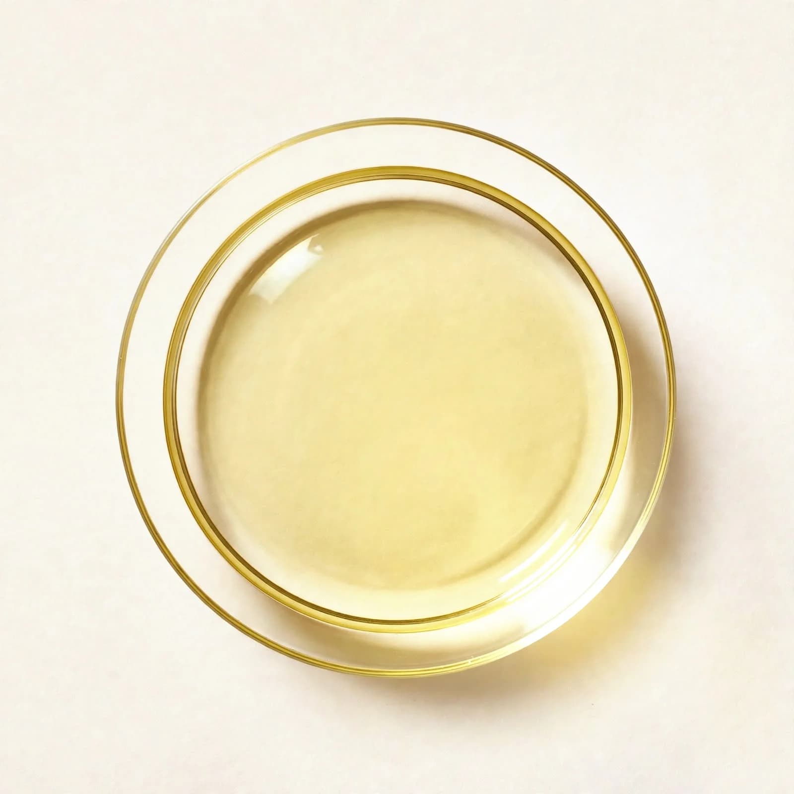 Pale golden stir-fry oil in a glass dish, seen from above.