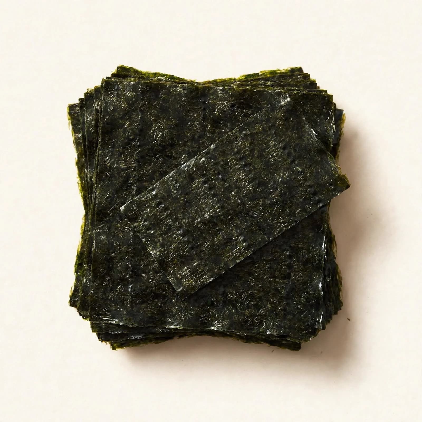 A stack of toasted nori sheets with one sheet laid across the top, seen from above.